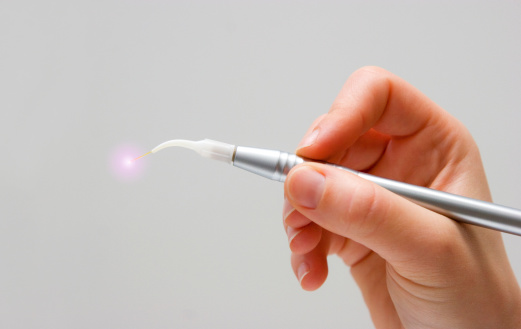 Close up of hand holding laser dentistry tool at D.A. Dental in Auburn, MA