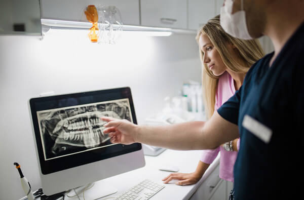 Dentist reviewing a digital xray" title="Dentist reviewing a digital xray